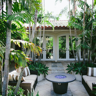 Foto di un patio o portico mediterraneo di medie dimensioni e in cortile con pavimentazioni in pietra naturale e una pergola