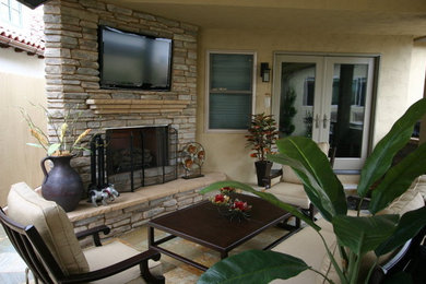 Inspiration for a mid-sized transitional backyard stone patio remodel in San Diego with a fire pit and a roof extension