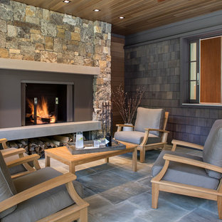 Esempio di un grande patio o portico stile rurale dietro casa con pavimentazioni in pietra naturale e un tetto a sbalzo