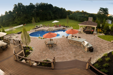 Inspiration for a large timeless backyard brick patio fountain remodel in Philadelphia with a pergola