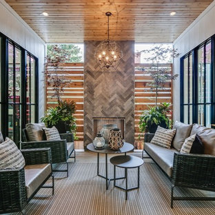 Photo of a country courtyard patio in Calgary with with fireplace and a roof extension.