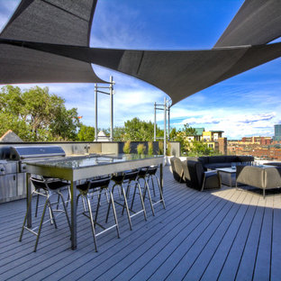 Immagine di un grande patio o portico design dietro casa con pedane e un parasole
