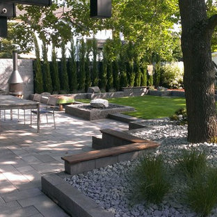 Idee per un grande patio o portico design con un tetto a sbalzo e un caminetto