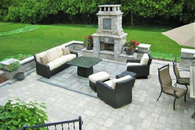 Mid-sized island style backyard brick patio photo in Chicago with a fireplace