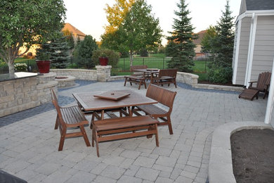 Inspiration for a huge contemporary backyard brick patio remodel in Chicago with a fire pit