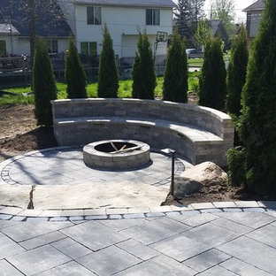 Esempio di un grande patio o portico minimalista dietro casa con un focolare, pavimentazioni in mattoni e nessuna copertura