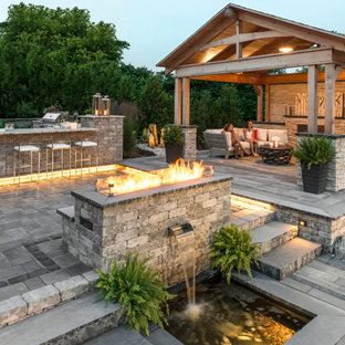 Patio kitchen - large transitional backyard concrete paver patio kitchen idea in New York with a pergola