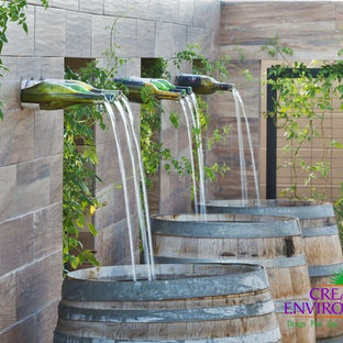 Idee per un patio o portico stile americano di medie dimensioni e dietro casa con fontane, ghiaia e nessuna copertura
