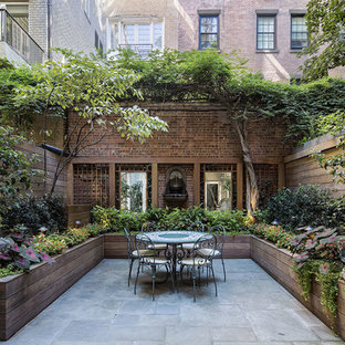 Immagine di un grande patio o portico tradizionale dietro casa con un giardino in vaso, nessuna copertura e pavimentazioni in pietra naturale