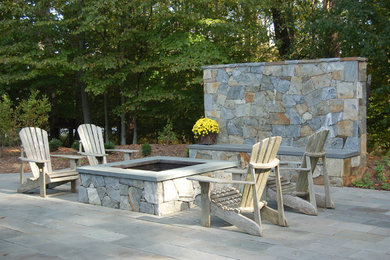 Diseño de patio clásico grande en patio trasero con brasero y adoquines de piedra natural