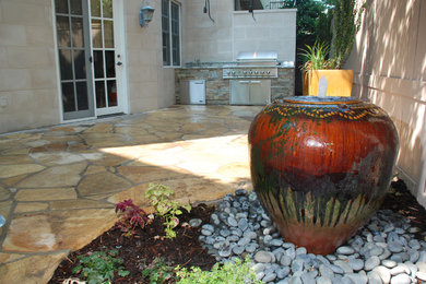 Inspiration for a mid-sized timeless backyard stone patio kitchen remodel in Dallas with no cover