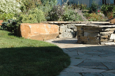 Ejemplo de patio ecléctico de tamaño medio en patio trasero con brasero y adoquines de piedra natural