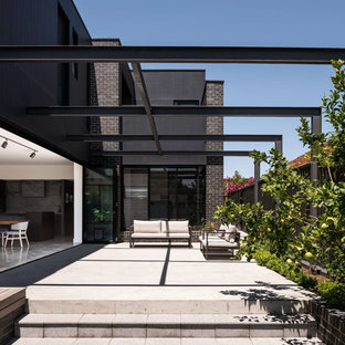 Idee per un patio o portico design nel cortile laterale con lastre di cemento e una pergola