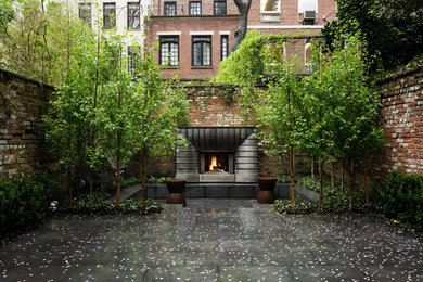 Imagen de patio actual sin cubierta en patio con adoquines de hormigón y chimenea