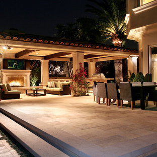 Esempio di un patio o portico mediterraneo di medie dimensioni e dietro casa con un gazebo o capanno e un focolare