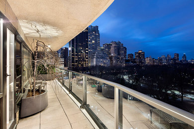 Inspiration for a large modern balcony remodel in New York with a roof extension