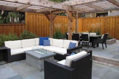 Example of a trendy backyard stone patio design in Chicago with a pergola