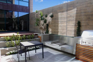 Example of a large minimalist backyard tile patio kitchen design in San Diego with no cover