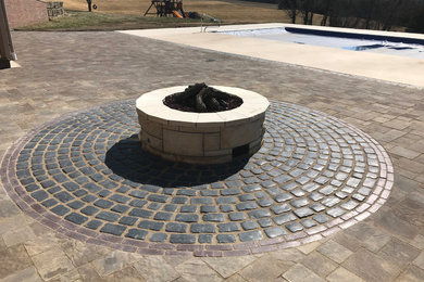 Patio - traditional backyard concrete paver patio idea in Other with a fire pit