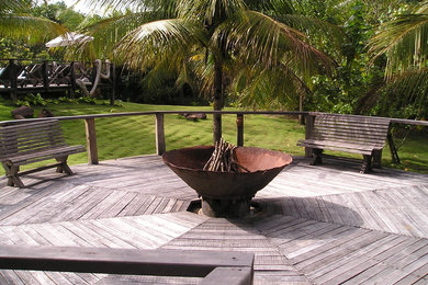 ハワイにある高級な広いラスティックスタイルのおしゃれな裏庭のテラス (ファイヤーピット、デッキ材舗装) の写真