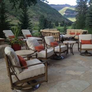 Foto di un ampio patio o portico boho chic dietro casa con un focolare, pavimentazioni in pietra naturale e nessuna copertura