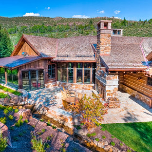 Immagine di un grande patio o portico rustico dietro casa con un focolare, pavimentazioni in mattoni e nessuna copertura