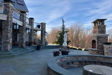 Example of a huge arts and crafts backyard tile patio design in Philadelphia with a fire pit and no cover