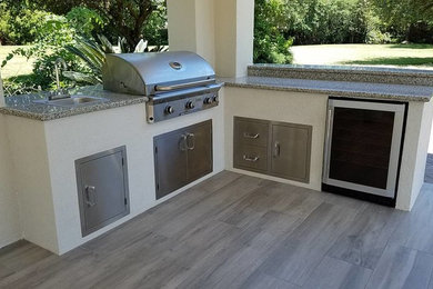 Inspiration for a mid-sized timeless backyard stone patio kitchen remodel in Houston with a roof extension