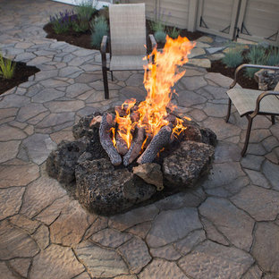 Foto di un grande patio o portico american style dietro casa con un focolare, pavimentazioni in pietra naturale e nessuna copertura
