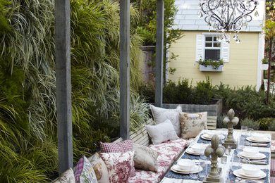 Exemple d'une terrasse arrière romantique avec une pergola.
