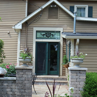 Idée de décoration pour une grande terrasse arrière victorienne avec des pavés en pierre naturelle.