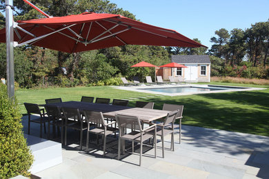Photo of a medium sized traditional back patio in Los Angeles with a water feature, an awning and concrete paving.