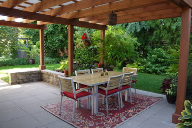 Imagen de patio vintage de tamaño medio en patio trasero con adoquines de hormigón