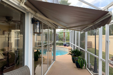 Patio - mid-sized contemporary side yard patio idea in Orlando with an awning