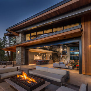 Cette photo montre une terrasse tendance avec un foyer extérieur.