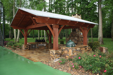 Modelo de patio tradicional de tamaño medio en patio trasero con cocina exterior, adoquines de piedra natural y pérgola