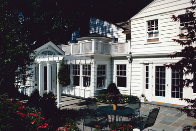 Imagen de patio clásico de tamaño medio en patio trasero con adoquines de piedra natural y pérgola