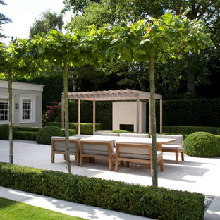 Immagine di un ampio patio o portico design dietro casa con pavimentazioni in pietra naturale e una pergola