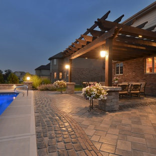Ispirazione per un grande patio o portico eclettico dietro casa con un focolare, pavimentazioni in cemento e una pergola