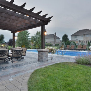 Immagine di un grande patio o portico eclettico dietro casa con un focolare, pavimentazioni in cemento e una pergola