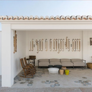Diseño de patio mediterráneo, en anexo de casas, con suelo de baldosas