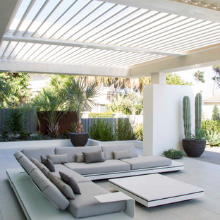 Imagen de patio actual, grande, en patio trasero, con suelo de baldosas y pérgola