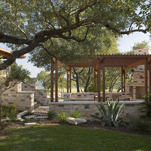 Ispirazione per un grande patio o portico stile americano dietro casa con un focolare, pavimentazioni in cemento e una pergola