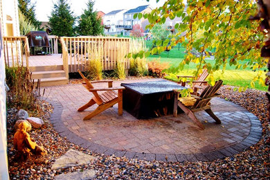 Diseño de patio de estilo americano de tamaño medio sin cubierta en patio trasero con brasero y adoquines de ladrillo