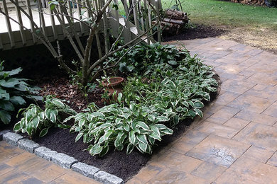 Mid-sized elegant backyard concrete paver patio photo in Other