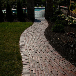 Foto di un grande patio o portico american style dietro casa con pavimentazioni in mattoni e nessuna copertura
