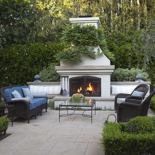 Idee per un grande patio o portico dietro casa con un focolare e pavimentazioni in cemento