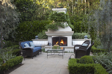 Patio - large french country backyard concrete paver patio idea in Los Angeles with a fire pit