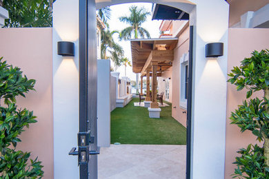 Walled-in outdoor covered lanai with custom fireplace and artificial greens