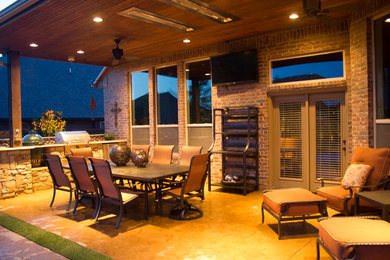 Exemple d'une terrasse arrière de taille moyenne avec une cuisine d'été, du béton estampé et une extension de toiture.